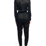 Faux silk jumpsuit with a cross over front, tapered leg, long sleeves, elasticized, tie waist and pockets in black