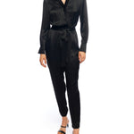 Faux silk jumpsuit with a cross over front, tapered leg, long sleeves, elasticized, tie waist and pockets in black