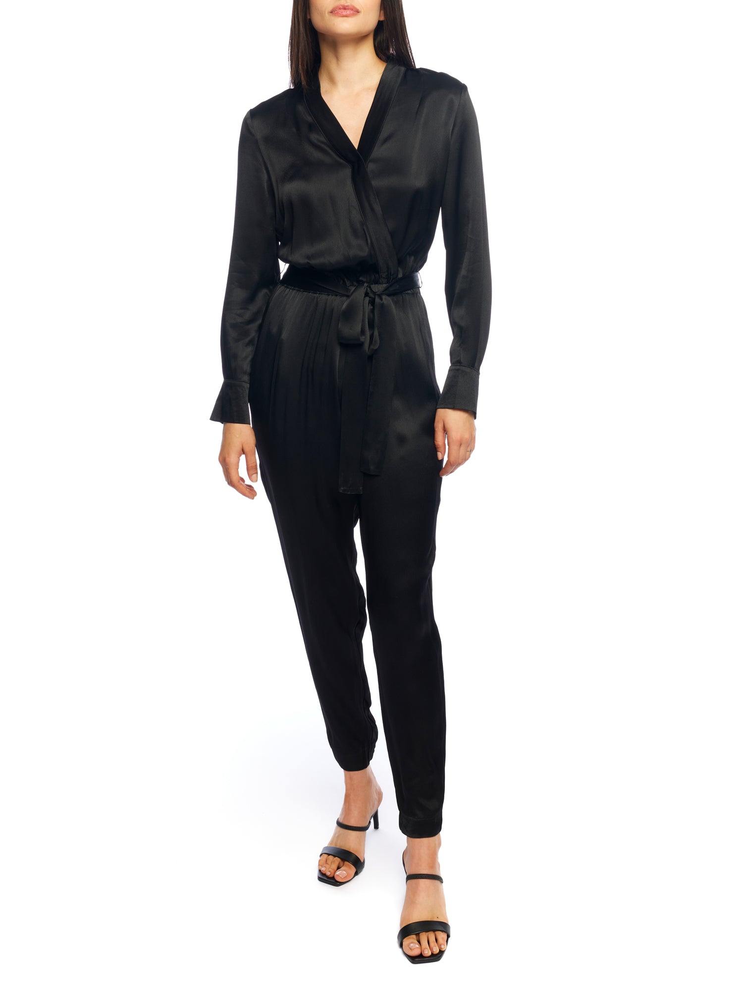 Faux silk jumpsuit with a cross over front, tapered leg, long sleeves, elasticized, tie waist and pockets in black