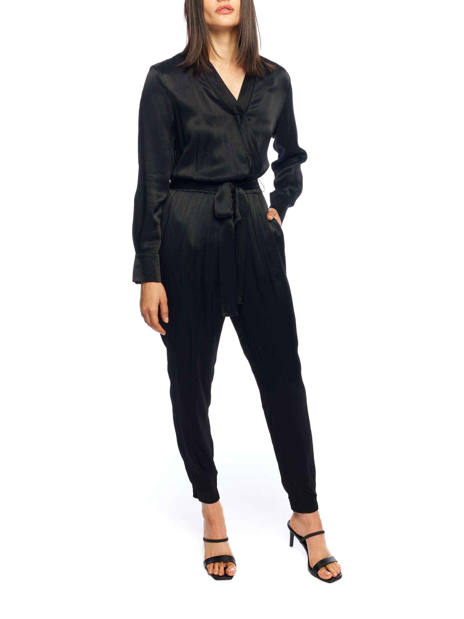 Faux silk jumpsuit with a cross over front, tapered leg, long sleeves, elasticized, tie waist and pockets in black