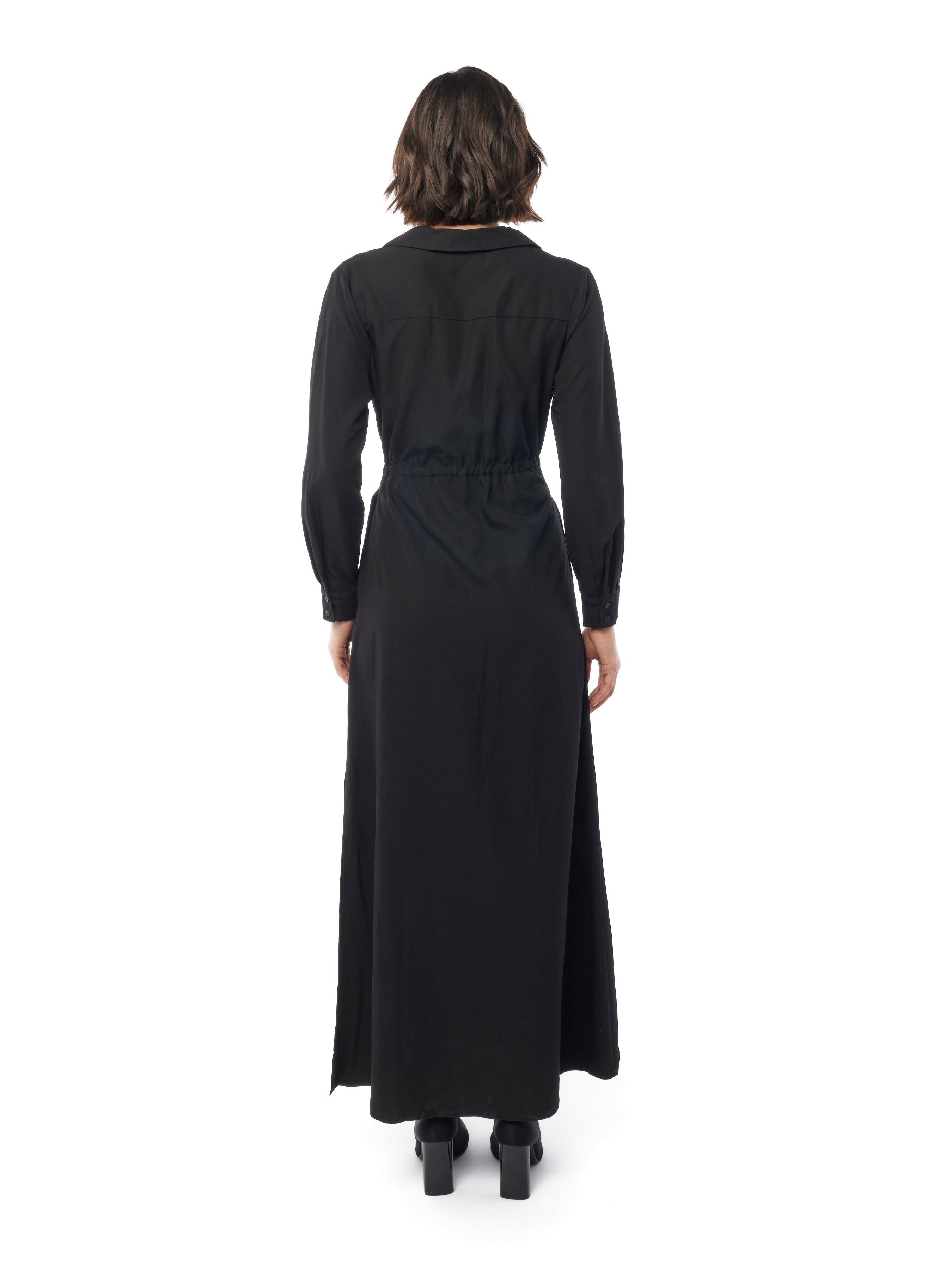 Long collared black dress with button down front, long cuffed sleeves and pockets. back view
