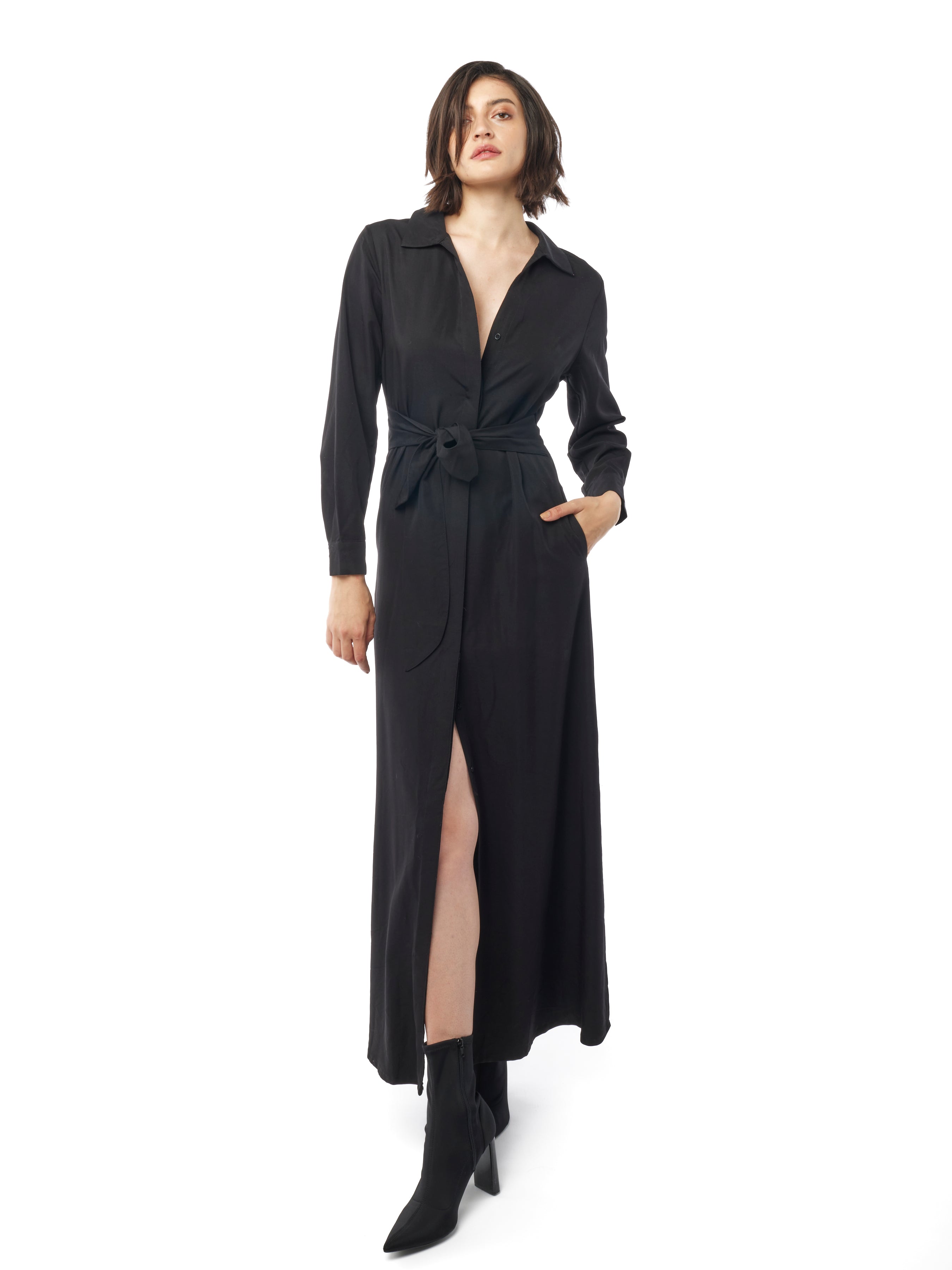 Long collared black dress with button down front, long cuffed sleeves and pockets. Front view