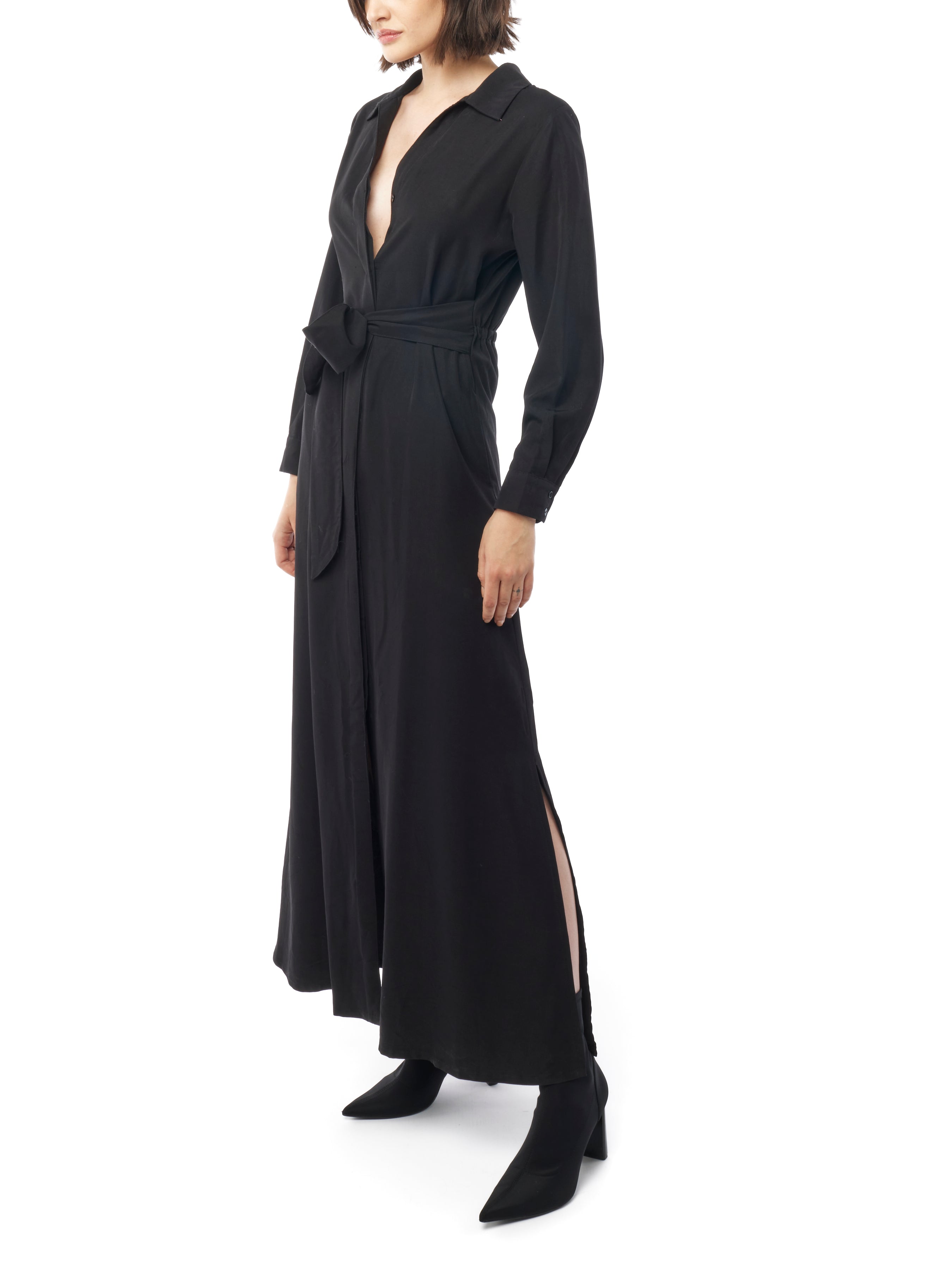 Long collared black dress with button down front, long cuffed sleeves and pockets. Side view