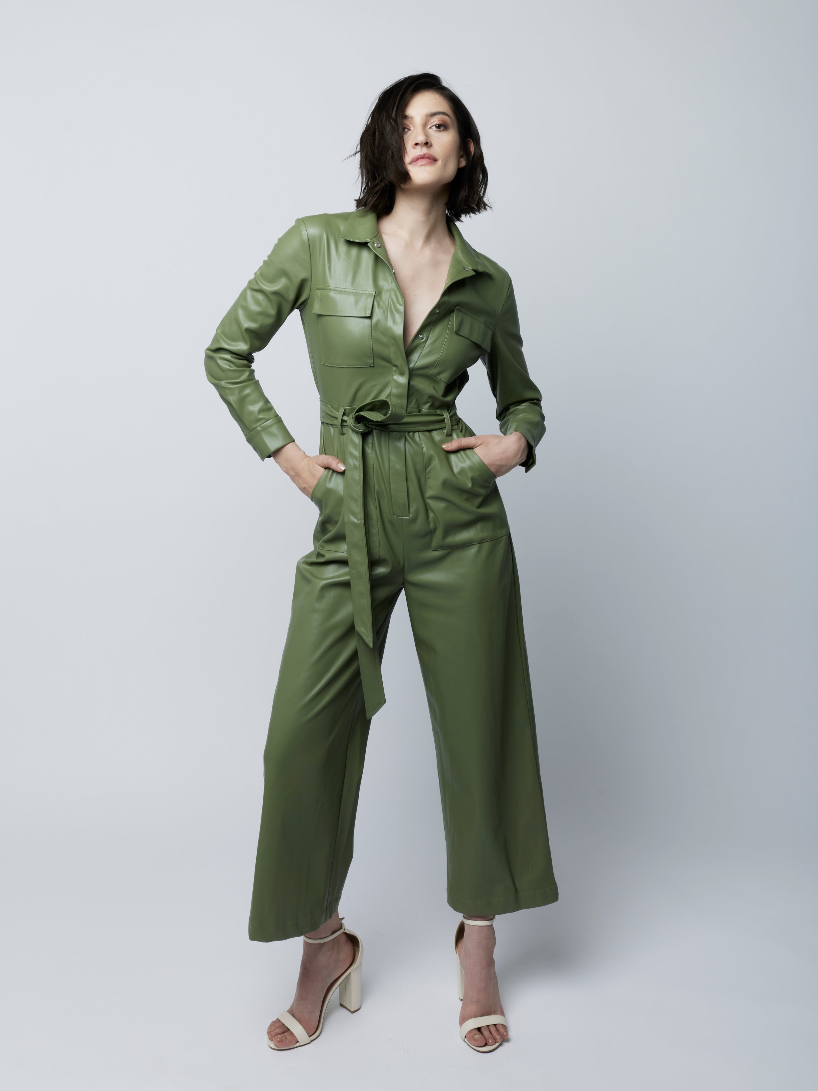 faux leather jumpsuit with long sleeves, wide legs, hidden snap front, pockets and detachable waist tie and elastic waist