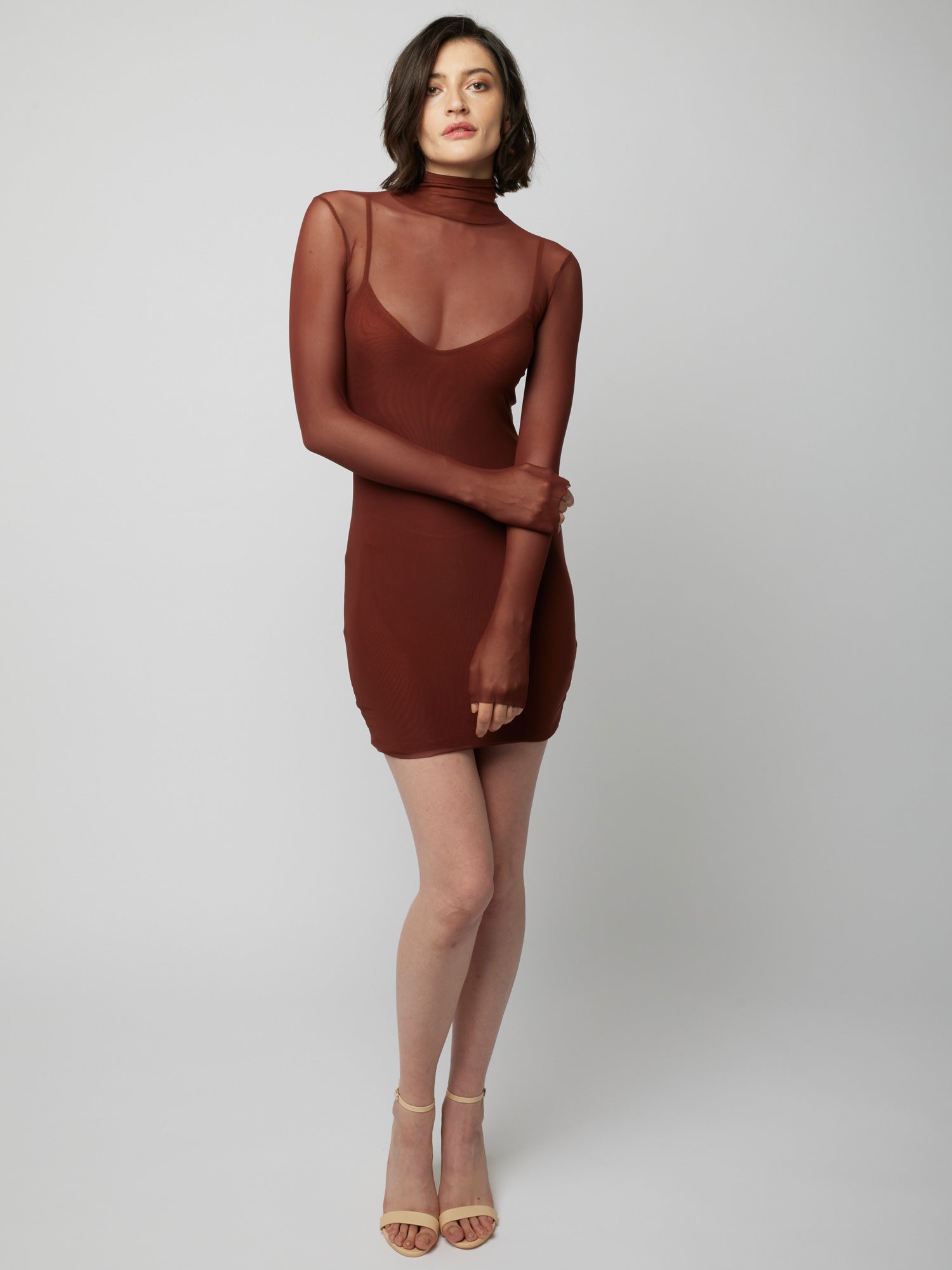 figure hugging, long sleeve mini dress with a sheer mock neck, sheer long sleeves with a spaghetti strap slip lining in rust