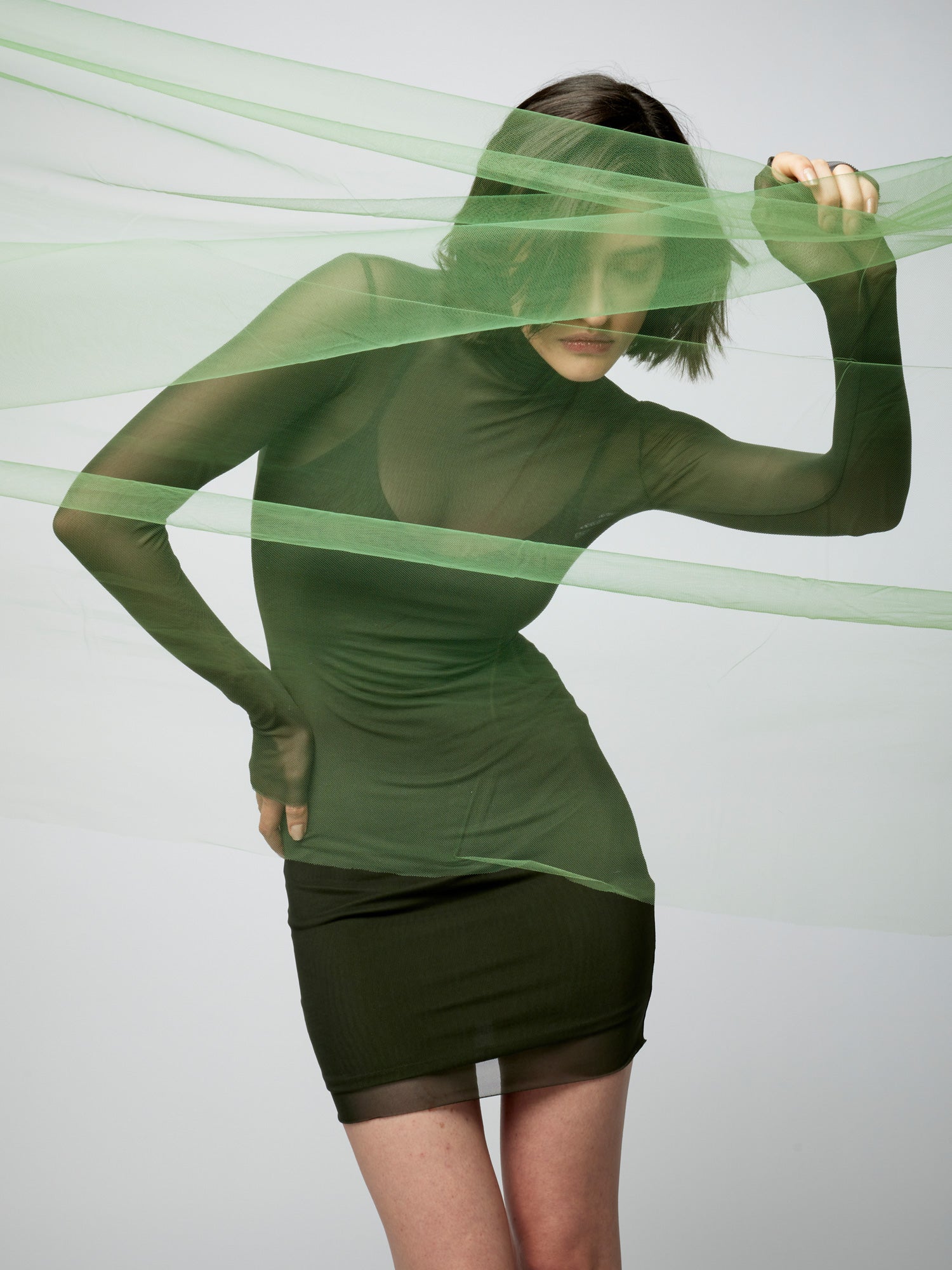 figure hugging, long sleeve mini dress with a sheer mock neck, sheer long sleeves with a spaghetti strap slip lining in olive